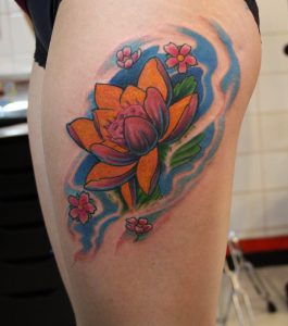 tatuagem feminina de flor de lótus na coxa