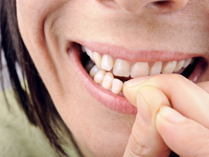 Dicas para parar de roer unha. Foto mulher roendo unha da mão