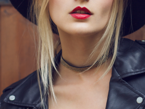 Gargantilha e chocker. Foto mostra uma mulher loira usando gargantilha preta com pedrinhas no pescoço.