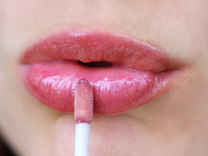 Lábios hidratados no Inverno. Foto mostra lábios recebendo gloss.