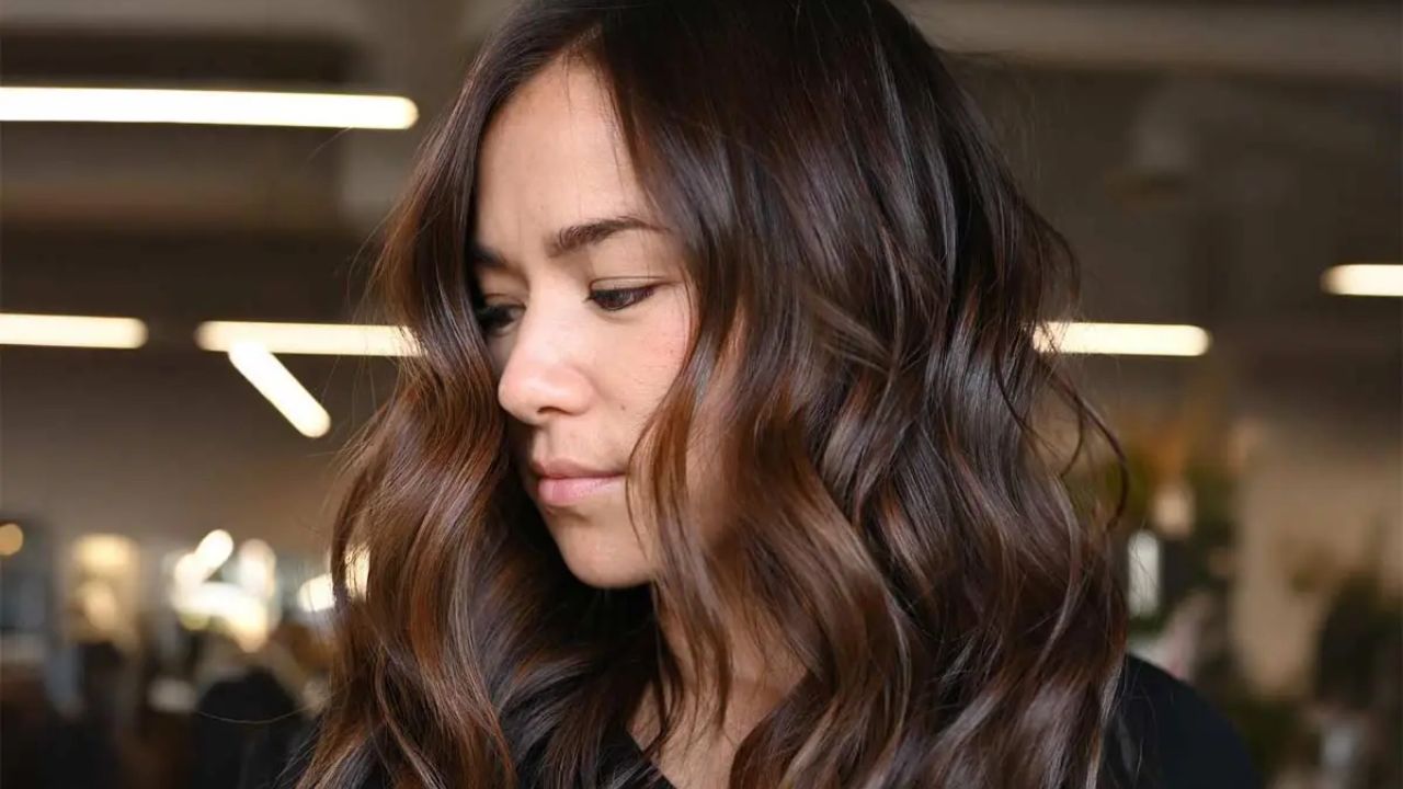 mulher com cabelo castanho escuro ondulado