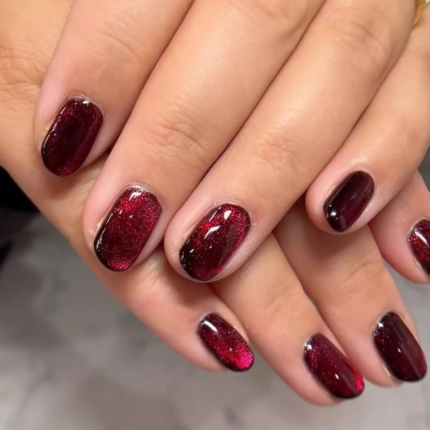 unhas em tom vermelho-escuro com glitter