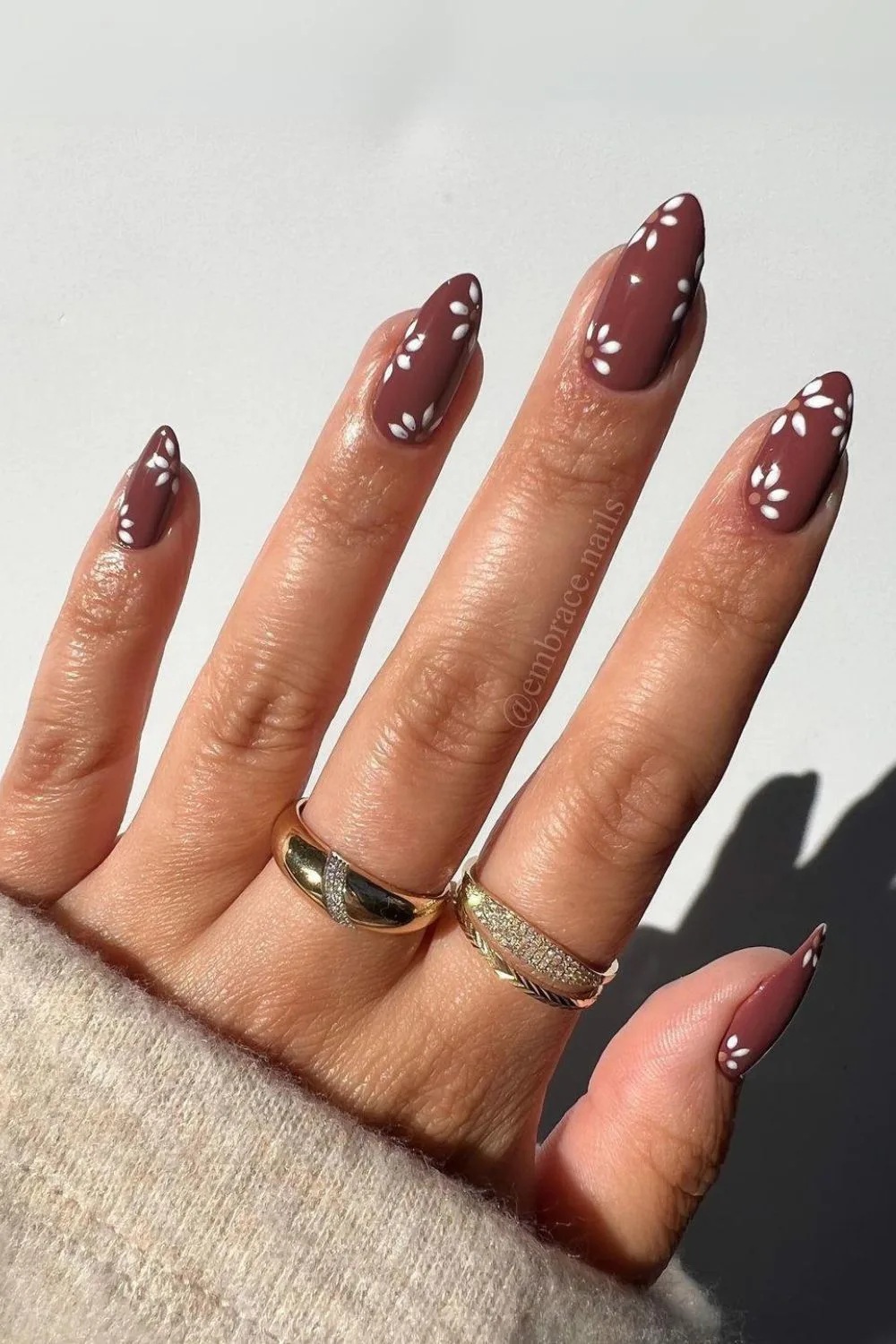 unhas marrons com flores brancas